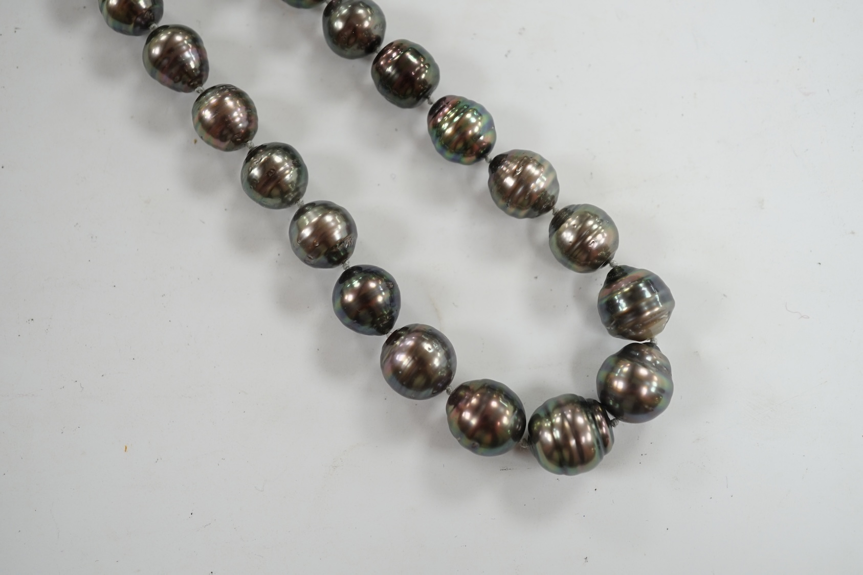 A modern single strand graduated Tahitian baroque cultured pearl necklace, with cabochon set yellow metal clasp, 48cm. Condition - fair to good